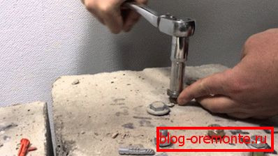 Zasuňte hmoždinku do betonové základny pomocí klíče Zasuňte hmoždinku do betonové základny pomocí klíče